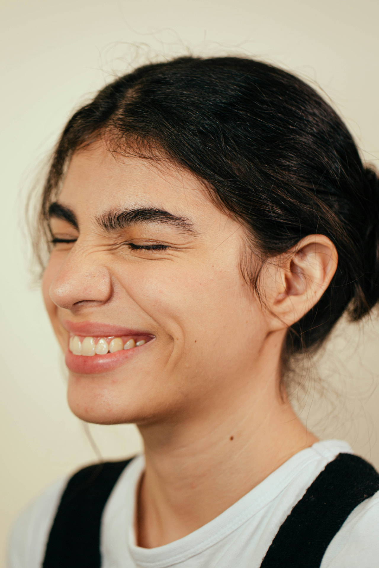 Mulher sorrindo de olhos fechados